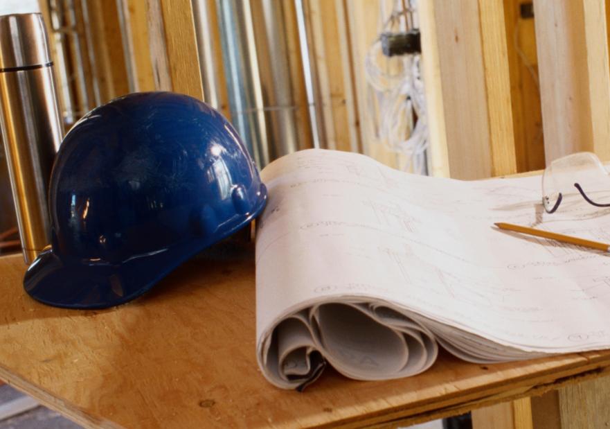 a hard hat and safety glasses on the table inside a home being built.